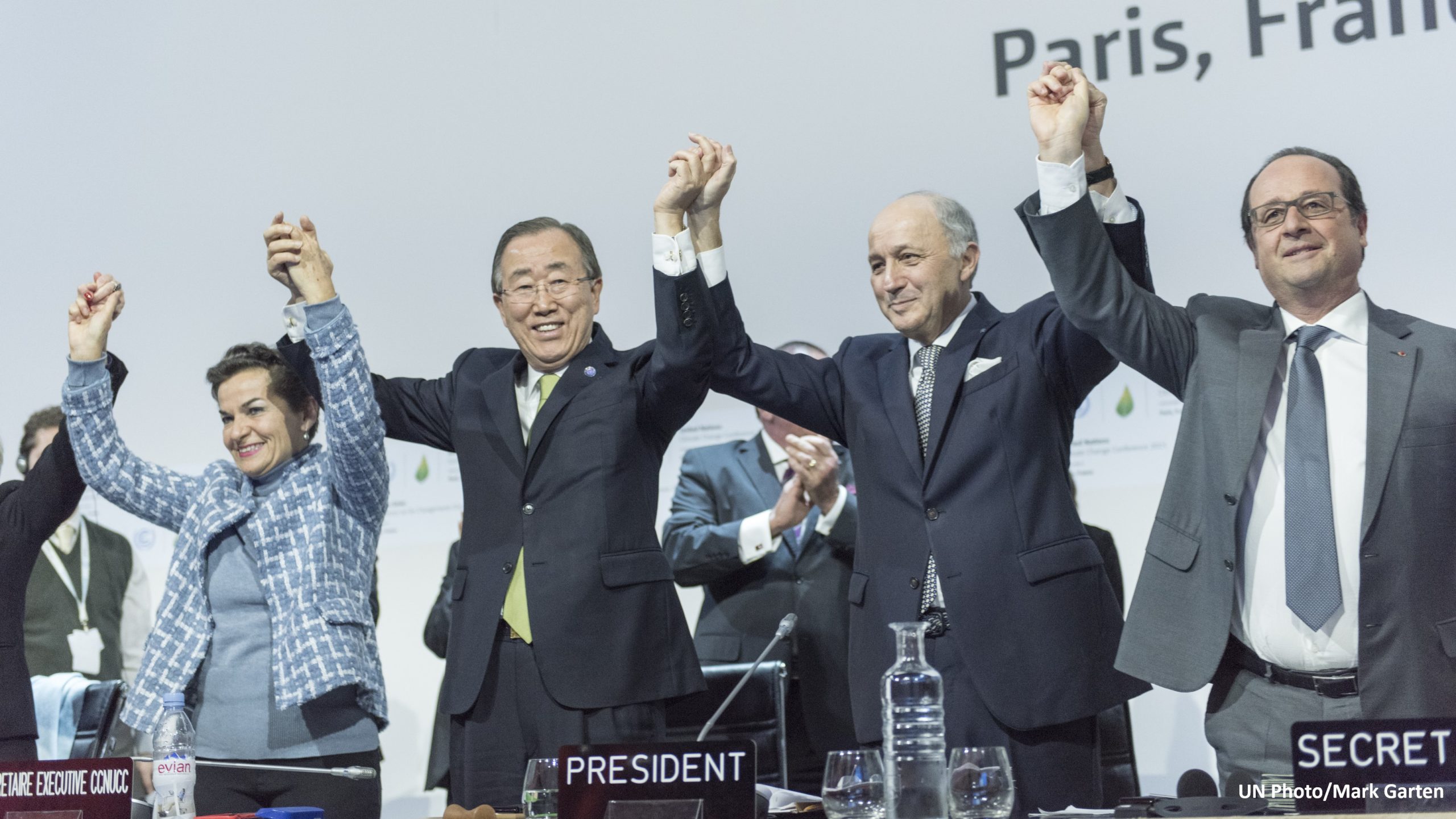 Le secrétaire général Ban Ki-moon (deuxième à gauche) ; Christiana Figueres (à gauche), secrétaire exécutive de la Convention-cadre des Nations unies sur les changements climatiques (CCNUCC) ; Laurent Fabius (deuxième à droite), ministre des Affaires étrangères de la France et président de la Conférence des Nations unies sur les changements climatiques à Paris (COP21) ; et François Hollande (à droite), président de la France, célèbrent l'adoption historique (2015) des Accords de Paris sur les changements climatiques.