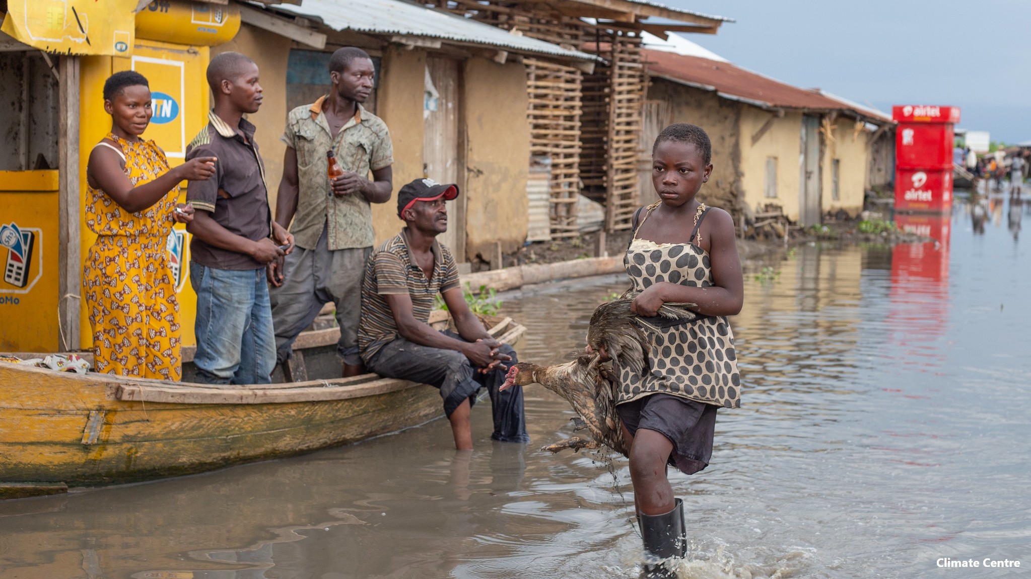 A girl, duck in hand wades through the water in Rwangara where Lake Albert levels caused the area to flood, destroying countless homes.